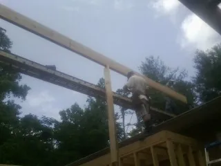 Carpenter setting a ridge beam over a new addition frame — Ice Dam Removal by Roofing Brothers in Tracy