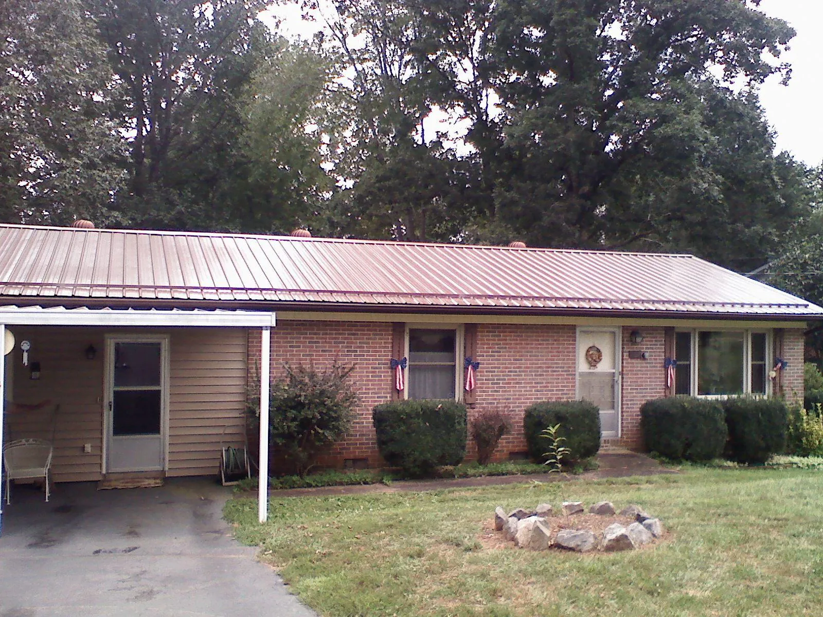 Bronze metal roof and carport on a brick ranch home — Roof Repair work by our crew in Tracy