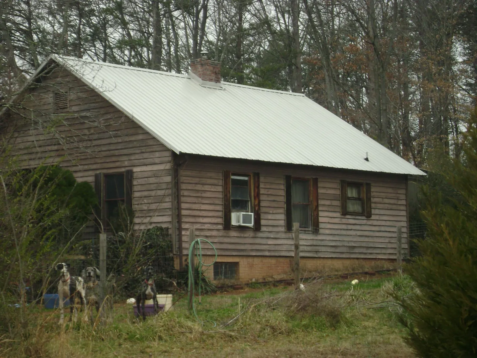 White metal roof on an old wood sided farmhouse, from a Metal Roof Installation job in Tracy